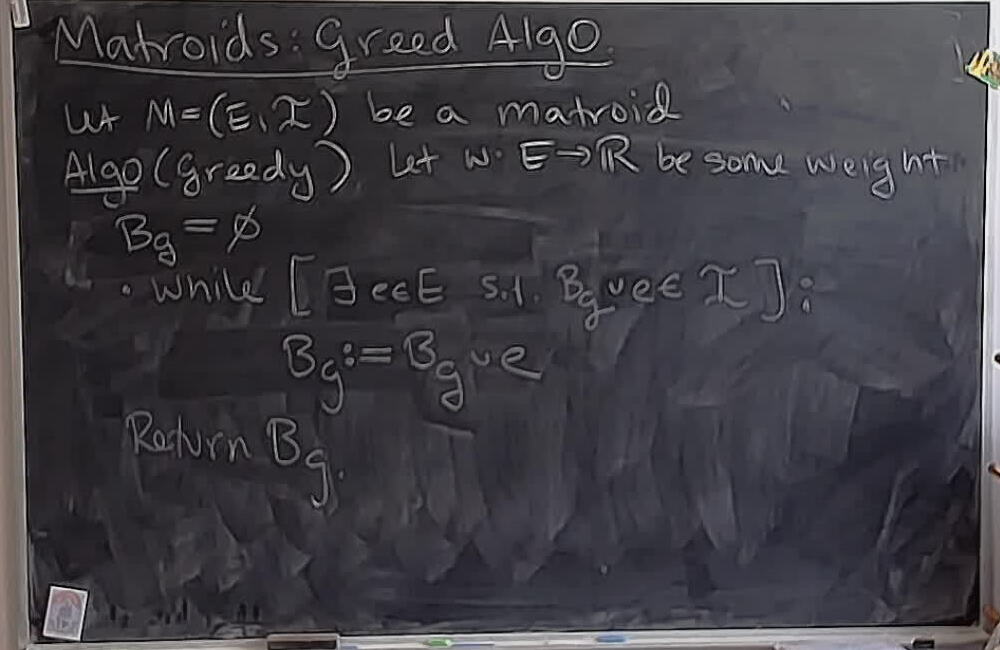 Matroids: Greedy Algorithm (Part 1) A photo of a whiteboard titled: Matroids: Greedy Algorithm (Part 1)